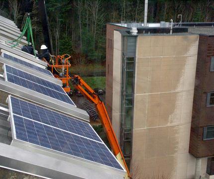 Solar panels being installed by a machine on a roof